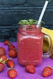 Köstliche Smoothies mit Erdbeeren und Banane Helle Sommerfarben lizenzfreies stockbild Köstliche Smoothies mit Erdbeeren und Banane Helle Sommerfarben lizenzfreies stockbild