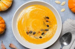 Kürbis-Suppe mit Sahne, Dill und Kürbiskerne, Draufsicht stockbild Kürbis-Suppe mit Sahne, Dill und Kürbiskerne, Draufsicht stockbild