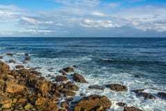Küste mit Felsen, Wellen, tiefes blaues Wasser, blaue Himmel mit whi stockbild Küste mit Felsen, Wellen, tiefes blaues Wasser, blaue Himmel mit whi stockbild