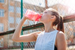 l'acqua potabile della giovane donna dell'atleta di forma fisica dopo risolve l'esercitazione del ritratto all'aperto fotografia stock l'acqua potabile della giovane donna dell'atleta di forma fisica dopo risolve l'esercitazione del ritratto all'aperto fotografia stock