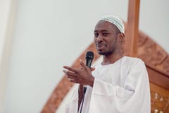 L'africain noir Imam de musulmans a une prière de la parole vendredi après-midi dans une mosquée image stock L'africain noir Imam de musulmans a une prière de la parole vendredi après-midi dans une mosquée image stock