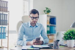 L'agent futé bel de sourire utilise son smartphone pour l'envoi photographie stock libre de droits L'agent futé bel de sourire utilise son smartphone pour l'envoi photographie stock libre de droits