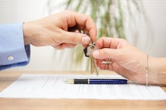 L'agente immobiliare fornisce le chiavi della casa al suo cliente dopo la firma della c Immagine Stock Libera da Diritti L'agente immobiliare fornisce le chiavi della casa al suo cliente dopo la firma della c Immagine Stock Libera da Diritti