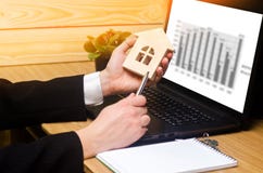 L'agente immobiliare tiene un modello della casa, si dei documenti dei materiali di riempimento dei segni fotografie stock libere da diritti L'agente immobiliare tiene un modello della casa, si dei documenti dei materiali di riempimento dei segni fotografie stock libere da diritti