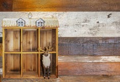 L'aiguille felted des orignaux avec des cloches sur des supports dans la grange en bois décorative avec le toit de bidon à un côt image stock L'aiguille felted des orignaux avec des cloches sur des supports dans la grange en bois décorative avec le toit de bidon à un côt image stock