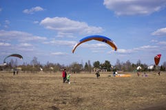 L'aliante vola contro il contesto dei campi, terra Vista da sopra paragliding fotografia stock libera da diritti L'aliante vola contro il contesto dei campi, terra Vista da sopra paragliding fotografia stock libera da diritti