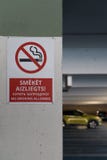 L'allower non-fumeurs rouge signent dans trois langues dans un stationnement souterrain avec des voitures évidentes à l'arrière-p photographie stock L'allower non-fumeurs rouge signent dans trois langues dans un stationnement souterrain avec des voitures évidentes à l'arrière-p photographie stock