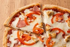 L'appartement s'étendent avec la pizza italienne traditionnelle avec le poulet, le jambon, le fromage et les tomates sur le dos e photo libre de droits L'appartement s'étendent avec la pizza italienne traditionnelle avec le poulet, le jambon, le fromage et les tomates sur le dos e photo libre de droits