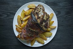 L'articulation frite de porc a servi avec des pommes de terre servies d'un plat blanc Fond en bois fonc? Vue de ci-avant images libres de droits L'articulation frite de porc a servi avec des pommes de terre servies d'un plat blanc Fond en bois fonc? Vue de ci-avant images libres de droits