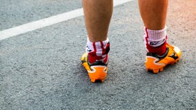 L'athlète courant à la route, se ferment vers le haut des pieds avec les chaussures de course et le St images libres de droits L'athlète courant à la route, se ferment vers le haut des pieds avec les chaussures de course et le St images libres de droits