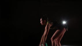 L'atleta attraente sveglio esile della ragazza in costume da bagno variopinto luminoso esegue gli elementi della ginnastica ritmi L'atleta attraente sveglio esile della ragazza in costume da bagno variopinto luminoso esegue gli elementi della ginnastica ritmi