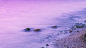 L'atmosphère romantique dans le matin paisible en mer Grands rochers collant de la mer onduleuse lisse photographie stock L'atmosphère romantique dans le matin paisible en mer Grands rochers collant de la mer onduleuse lisse photographie stock