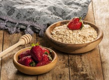 L'avoine s'écaille dans la cuvette avec la fraise sur la table en bois photo libre de droits L'avoine s'écaille dans la cuvette avec la fraise sur la table en bois photo libre de droits