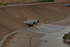 L'eau de versement de barrage noir d'Aroyo que le drainage siffle un jour pluvieux photographie stock libre de droits L'eau de versement de barrage noir d'Aroyo que le drainage siffle un jour pluvieux photographie stock libre de droits