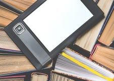 L'eBook avec un écran blanc se trouve sur les livres multicolores ouverts qui se trouvent sur un fond foncé, en gros plan images stock L'eBook avec un écran blanc se trouve sur les livres multicolores ouverts qui se trouvent sur un fond foncé, en gros plan images stock