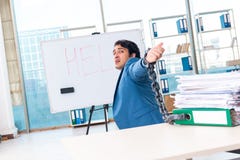 L'employ? masculin encha?n? peu satisfait du travail excessif photographie stock L'employ? masculin encha?n? peu satisfait du travail excessif photographie stock