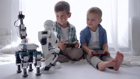 L'enfance, de petits garçons commandent des robots utilisant des téléphones portables jouant ensemble au week-end à la maison L'enfance, de petits garçons commandent des robots utilisant des téléphones portables jouant ensemble au week-end à la maison
