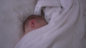 L'enfant en bas âge dort gentiment sur le grand lit avec des toiles blanches dans le mouvement lent banque de vidéos L'enfant en bas âge dort gentiment sur le grand lit avec des toiles blanches dans le mouvement lent banque de vidéos