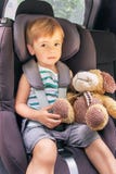 L'enfant s'assied dans le siège de voiture de sécurité photographie stock libre de droits L'enfant s'assied dans le siège de voiture de sécurité photographie stock libre de droits