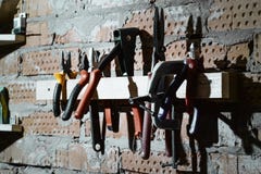 L'ensemble de mâle différent usine la vue sur le mur de briques du garage, atelier Pinces, coupeurs, un étau, ciseaux, agrafeuse photographie stock libre de droits L'ensemble de mâle différent usine la vue sur le mur de briques du garage, atelier Pinces, coupeurs, un étau, ciseaux, agrafeuse photographie stock libre de droits
