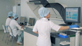 L'esperto femminile nel laboratorio sta manipolando l'analizzatore biochimico su uno schermo attivabile al tatto in una fabbrica archivi video L'esperto femminile nel laboratorio sta manipolando l'analizzatore biochimico su uno schermo attivabile al tatto in una fabbrica archivi video