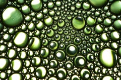 L'estratto bolle olio vegetale sull'acqua Fondo luminoso e riflettente verde Fotografie Stock L'estratto bolle olio vegetale sull'acqua Fondo luminoso e riflettente verde Fotografie Stock