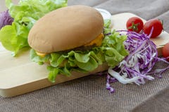 L'hamburger est pr?par? avec du porc grill?, le fromage, les tomates, la laitue et le chou pourpre sur la table images libres de droits L'hamburger est pr?par? avec du porc grill?, le fromage, les tomates, la laitue et le chou pourpre sur la table images libres de droits