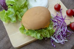 L'hamburger est préparé avec du porc grillé, le fromage, les tomates, la laitue et le chou pourpre sur la table images stock L'hamburger est préparé avec du porc grillé, le fromage, les tomates, la laitue et le chou pourpre sur la table images stock