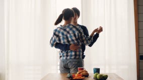 L'homme adorable et la femme de couples sont dansants et embrassants dans la cuisine à la maison portant des vêtements décontract banque de vidéos L'homme adorable et la femme de couples sont dansants et embrassants dans la cuisine à la maison portant des vêtements décontract banque de vidéos