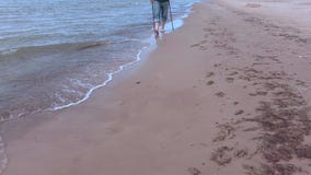 L'homme avec la hausse colle la marche le long du bord de la mer clips vidéos L'homme avec la hausse colle la marche le long du bord de la mer clips vidéos