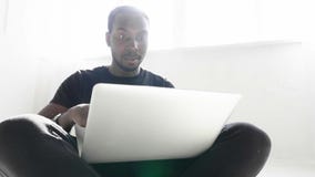 L'homme d'affaires afro-américain bel dans des vêtements sport utilise un ordinateur banque de vidéos L'homme d'affaires afro-américain bel dans des vêtements sport utilise un ordinateur banque de vidéos