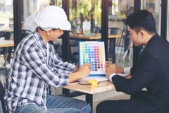 L'homme d'affaires et l'ingénieur discutant un certain projet, choisissent des couleurs photo stock L'homme d'affaires et l'ingénieur discutant un certain projet, choisissent des couleurs photo stock