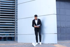L'homme d'affaires masculin arabe d'homme rassemble des papiers et des documents près d'o photographie stock L'homme d'affaires masculin arabe d'homme rassemble des papiers et des documents près d'o photographie stock