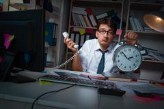 L'homme d'affaires d'homme travaillant des heures en retard dans le bureau Photos stock L'homme d'affaires d'homme travaillant des heures en retard dans le bureau Photos stock
