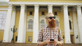 L'homme de touristes barbu a perdu la ville et en employant la carte en ligne de smartphone pour trouver de bonnes directions images libres de droits L'homme de touristes barbu a perdu la ville et en employant la carte en ligne de smartphone pour trouver de bonnes directions images libres de droits