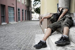 L'homme dépendant aux drogues se trouve sur un doorste photographie stock libre de droits L'homme dépendant aux drogues se trouve sur un doorste photographie stock libre de droits