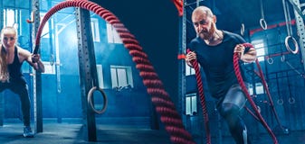 L'homme et la femme avec des cordes de bataille de corde de bataille s'exercent dans le gymnase de forme physique photo libre de droits L'homme et la femme avec des cordes de bataille de corde de bataille s'exercent dans le gymnase de forme physique photo libre de droits
