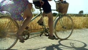 L'homme et la femme de déplacement de couples montent un tandem de vélo au champ d'été de passé de route dessus banque de vidéos L'homme et la femme de déplacement de couples montent un tandem de vélo au champ d'été de passé de route dessus banque de vidéos