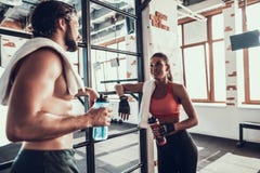 L'homme et la femme parlent pendant la coupure dans le gymnase photos libres de droits L'homme et la femme parlent pendant la coupure dans le gymnase photos libres de droits