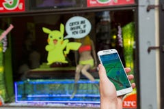 L'homme jouant Pokemon vont extérieur Photo libre de droits L'homme jouant Pokemon vont extérieur Photo libre de droits