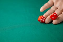 L'homme juge deux rouges les découpe et jette sur la table de jeu verte de tisonnier dans le casino Concept du jeu en ligne, du g photo stock L'homme juge deux rouges les découpe et jette sur la table de jeu verte de tisonnier dans le casino Concept du jeu en ligne, du g photo stock