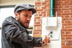 L'homme serre un écrou photographie stock libre de droits L'homme serre un écrou photographie stock libre de droits