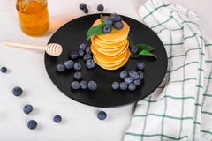 L'image montre une crêpe pelucheuse faite maison avec la myrtille et la menthe sur le dessus ; la situation est décorée de la tab photo libre de droits L'image montre une crêpe pelucheuse faite maison avec la myrtille et la menthe sur le dessus ; la situation est décorée de la tab photo libre de droits