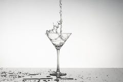 L'immagine in bianco e nero di un vetro di martini con spruzza fotografie stock L'immagine in bianco e nero di un vetro di martini con spruzza fotografie stock