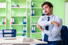 L'impiegato che fa gli esercizi durante la pausa sul lavoro Fotografie Stock Libere da Diritti L'impiegato che fa gli esercizi durante la pausa sul lavoro Fotografie Stock Libere da Diritti