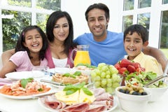 L'indiano asiatico Parents la famiglia dei bambini che mangia l'alimento fotografia stock libera da diritti L'indiano asiatico Parents la famiglia dei bambini che mangia l'alimento fotografia stock libera da diritti