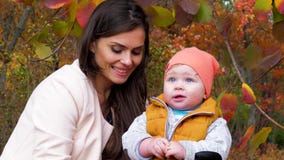 L'infanzia e la maternità felice, la mummia ed il bambino in autunno parcheggiano divertiresi all'aperto il primo piano su fondo stock footage L'infanzia e la maternità felice, la mummia ed il bambino in autunno parcheggiano divertiresi all'aperto il primo piano su fondo stock footage