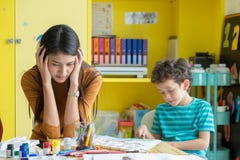 L'insegnante asiatico della donna ottiene l'emicrania con i bambini del ragazzo impertinente nel classr fotografia stock libera da diritti L'insegnante asiatico della donna ottiene l'emicrania con i bambini del ragazzo impertinente nel classr fotografia stock libera da diritti
