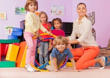 L'insegnante, bambini nell'asilo gioca il gioco con il cerchio fotografie stock libere da diritti L'insegnante, bambini nell'asilo gioca il gioco con il cerchio fotografie stock libere da diritti