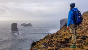 L'Islanda - condizione del giovane su una scogliera immagini stock libere da diritti L'Islanda - condizione del giovane su una scogliera immagini stock libere da diritti
